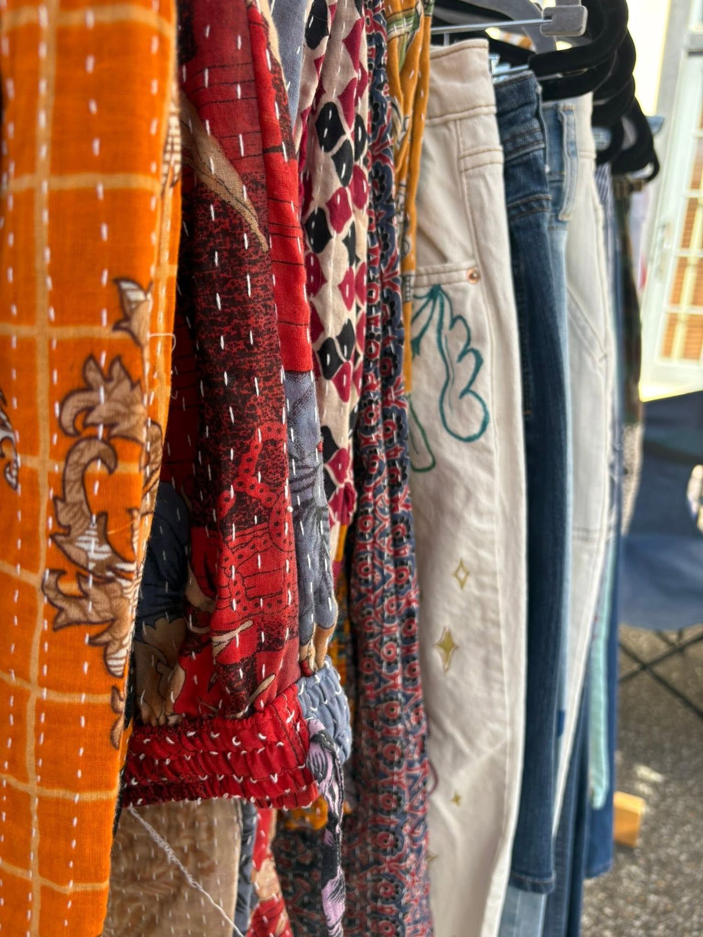 A rack of Filthy Rags clothing in hand-stitched patchwork cloth and denim